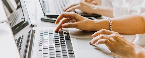 hands typing on laptops